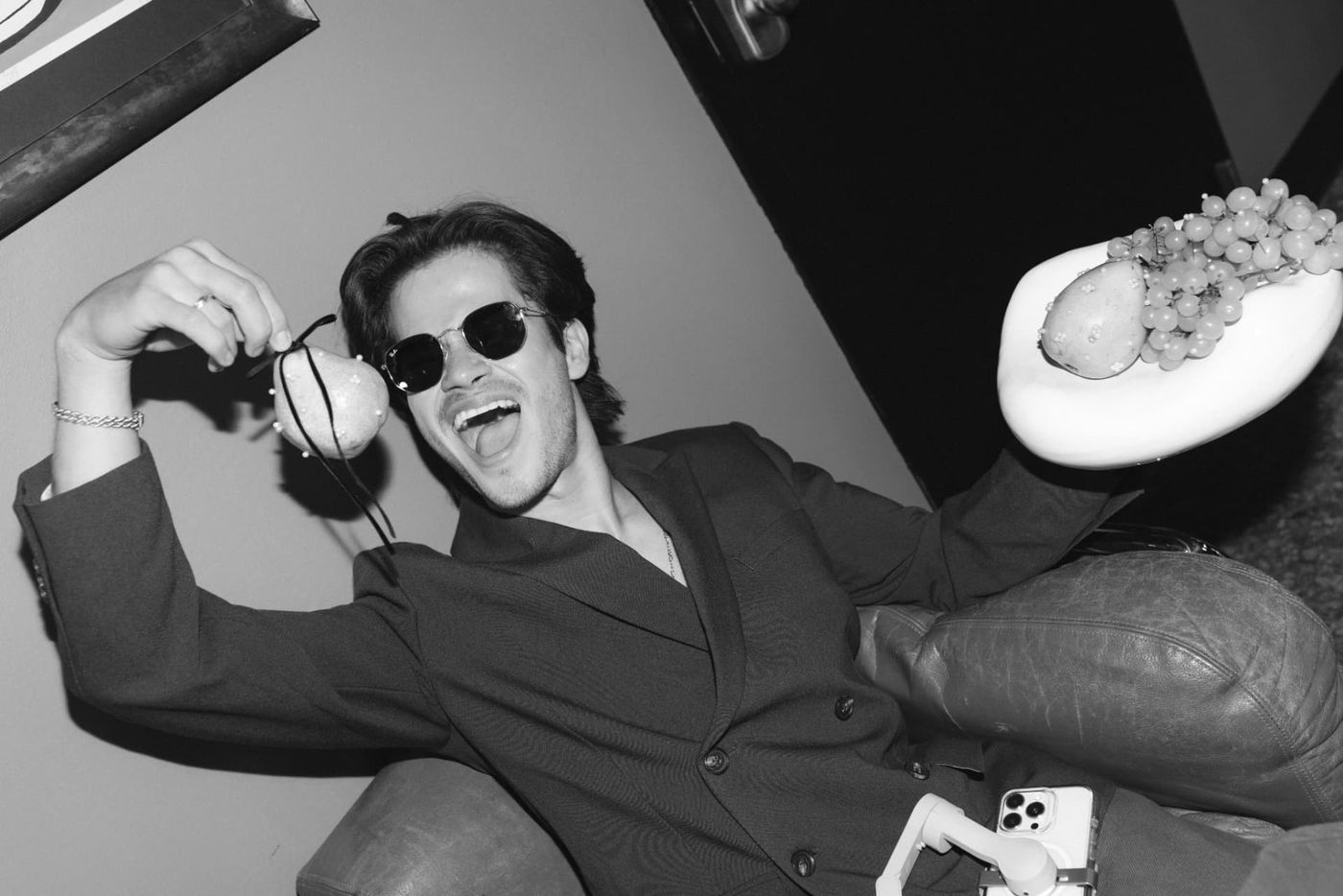 Jose laughing with pearl-studded pears, black and white